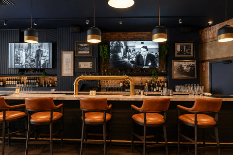 Bar area with leather chairs, television screens, and a well-stocked bar.