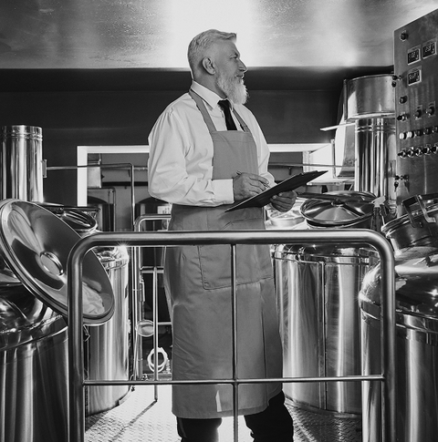 Brewer inspecting brewing equipment at House of McGrath brewery.