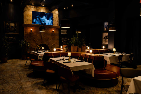 Dining area with tables and chairs in a dimly lit House of McGrath restaurant setting.