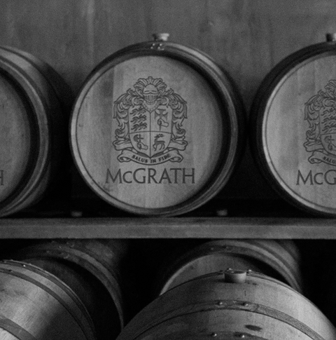 Wooden barrels with McGrath logo in a storage room